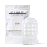 A white silicone massage glove with soft spikes, next to its packaging labeled 'GANT DE MASSAGE CORPS'.